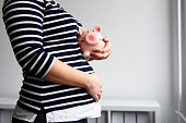 Pregnant woman with piggy bank