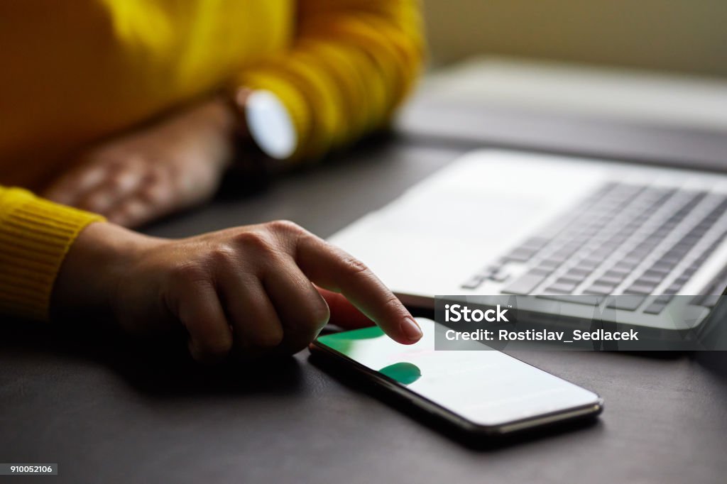 Female hands with mobile phone and laptop Female hands with mobile phone and laptop in the office Adult Stock Photo