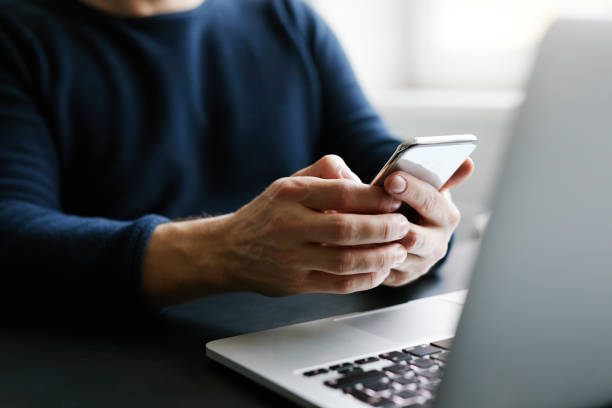 istock Man with mobile phone and laptop 910052158
