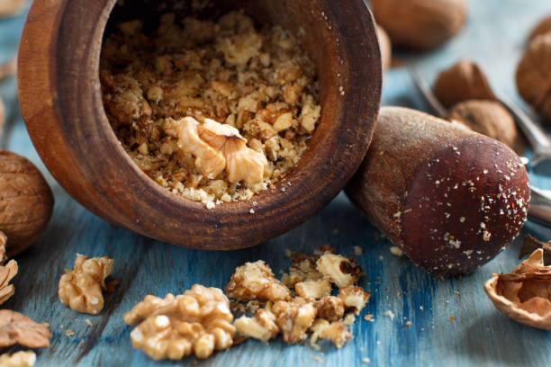 istock Fresh walnuts and mortar on a blue wooden table 910052702