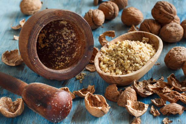 istock Fresh walnuts and mortar on a blue wooden table 910052716