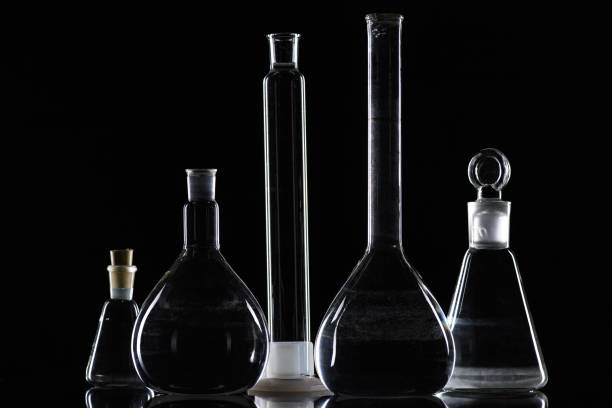 istock transparent glass flasks with substance in laboratory on black 910052868