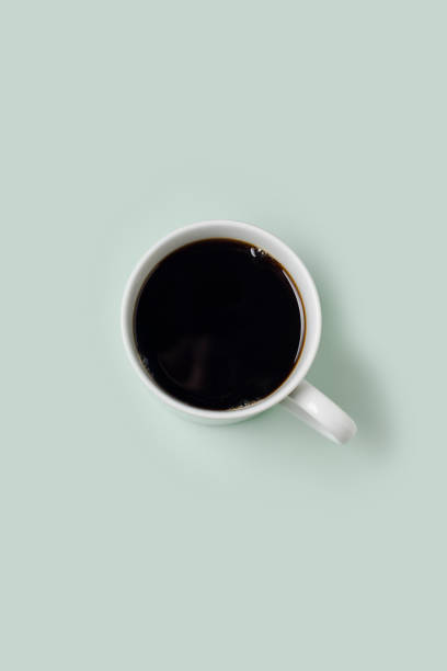 istock Mug of black coffee against pale green. 910053482