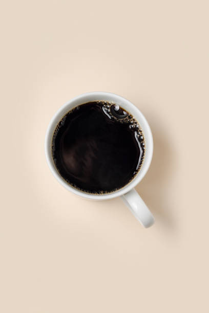 Mug of black coffee against a yellow background. Mug of black coffee against a yellow background. black coffee from above stock pictures, royalty-free photos & images