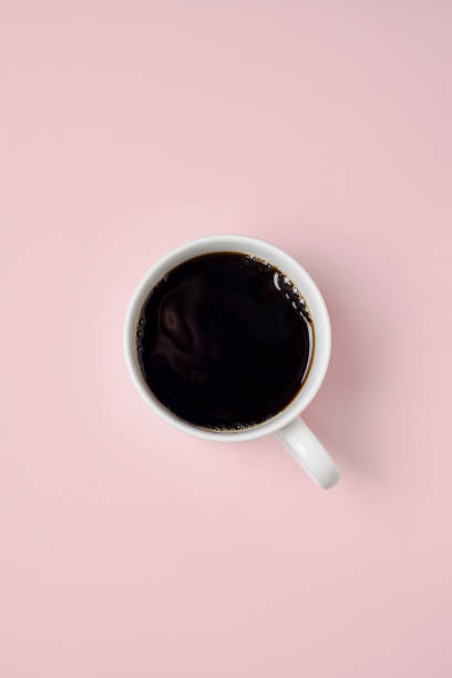 istock Mug of black coffee against a pink background. 910053494