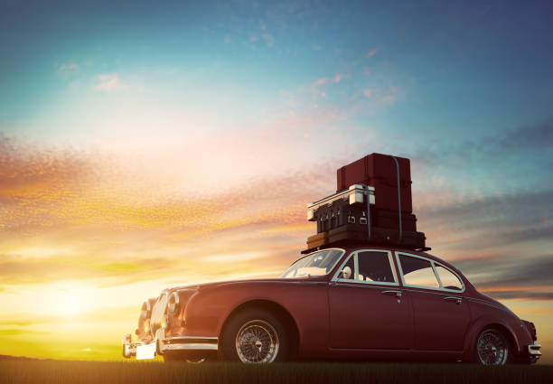 夕暮れ時の屋根のラックに荷物をレトロな赤い車。旅行、休暇の概念。 - trunk luggage old fashioned retro revival ストックフォトと画像