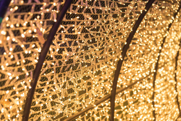 istock Bulbs glitter in tunnel lights and gold bokeh background, Blurred background. 910066690