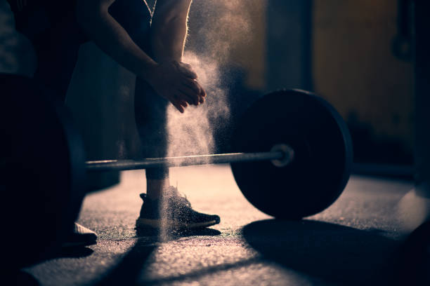 Weight lifting Unrecognizable male athlete preparing for dead lift exercise with a barbell. crossfit chalk weightlifting weight training stock pictures, royalty-free photos & images