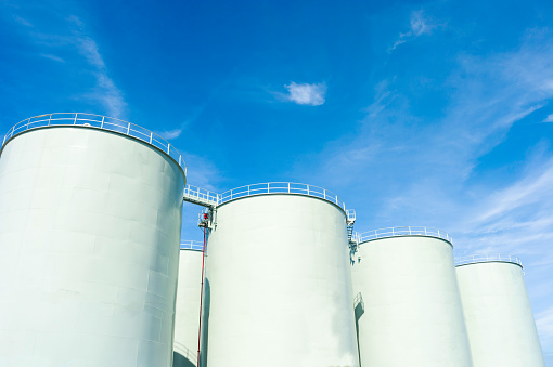 SILOS IN INDUSTRIAL FACTORY , CLEAR BLUE SKY CLOUD SUNNY DAY BACKGROUND