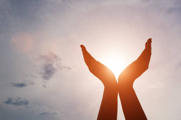 levantó las manos cogiendo sol en el cielo al atardecer. concepto de espiritualidad, el bienestar, la energía positiva - hand raised fotos fotografías e imágenes de stock