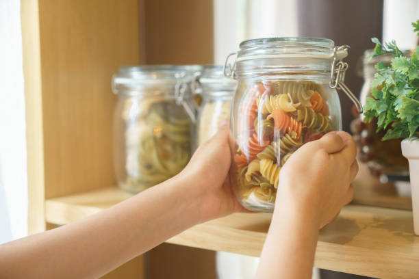 istock Hands picking macaroni in glass jar for preparing food 910090318