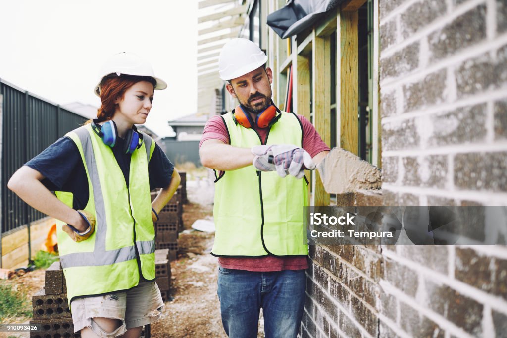 Construction workers in Australian in building site working and doing tasks. SydneyConstruction Trainee Stock Photo