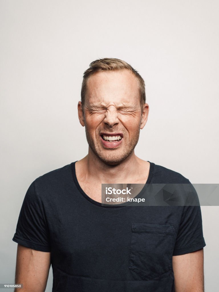 Mid adult man with expression feelings on his face studio shot series in pain eyes closed Mid adult man with expression feelings on his face studio shot series. in pain eyes closed. Pain Stock Photo