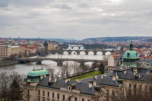 Panorama of the old part of Prague from the Letna park. Beautiful view on the bridges over the river Vltava at cloudy winter day. View on Straka Academy from Hanau pavilion. Czech Republic.