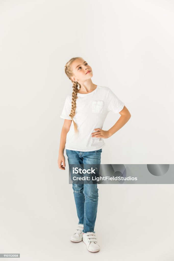 child standing with hand on hip and looking up isolated beautiful pensive child standing with hand on hip and looking up isolated on white Girls Stock Photo