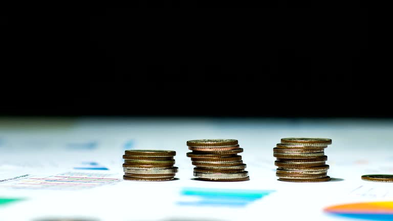 Time-lapse video of Stacking Coin on Financial Document, Dolly shot.