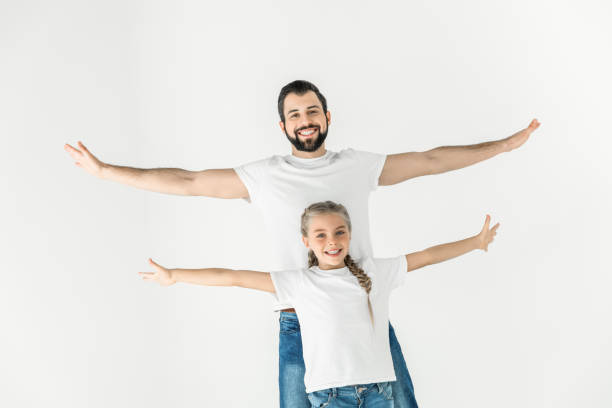 happy father and daughter standing with open arms and smiling at camera isolated on white