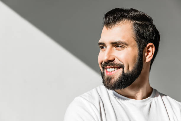 istock bearded man smiling and looking away on grey 910119072
