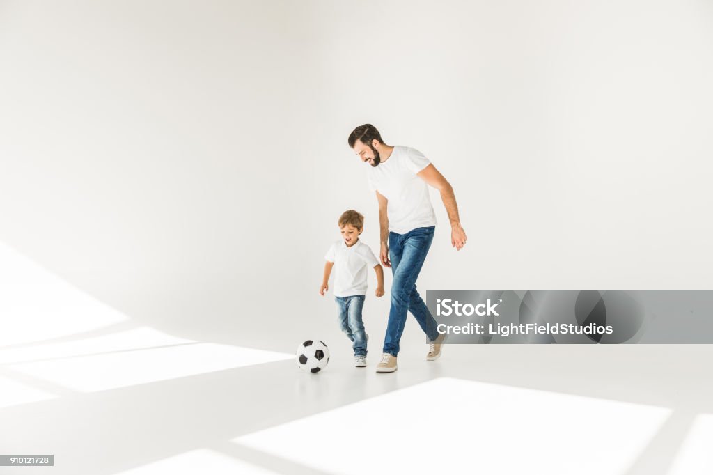 father and son with soccer ball full length view of happy father and son playing together with soccer ball on white Father Stock Photo