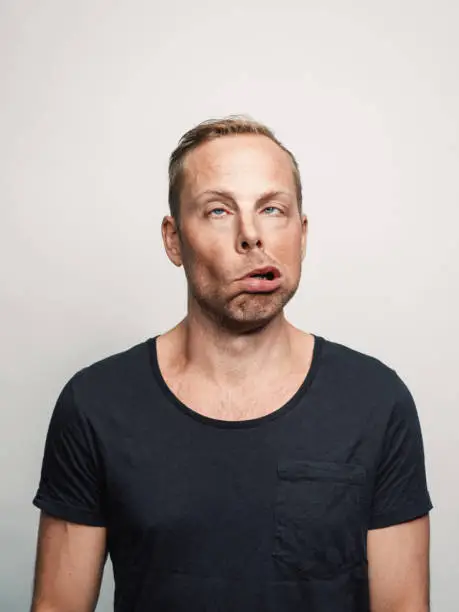 Photo of Mid adult man with expression feelings on his face studio shot series wierd and deformed