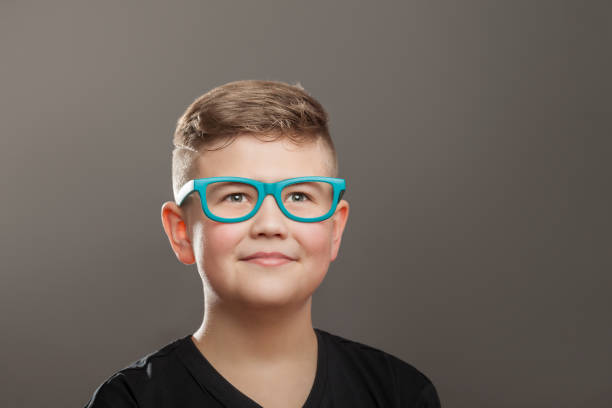 istock Teenager boy with eyeglasses on grey background 910132390