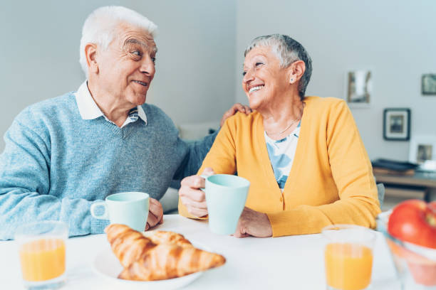 istock Smiling senior couple talking at the table 910135992
