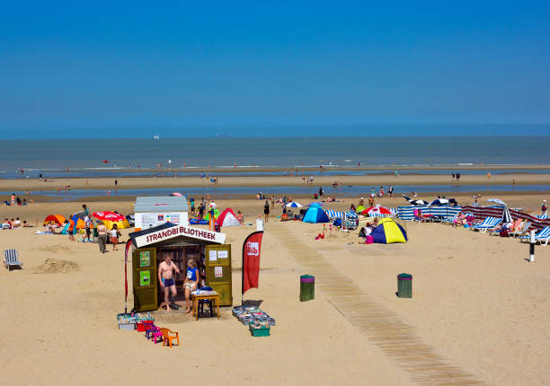bibliotheek op het noordzee strand en zonnebaden mensen in blankenberge, belgië - blankenberge strand stockfoto's en -beelden
