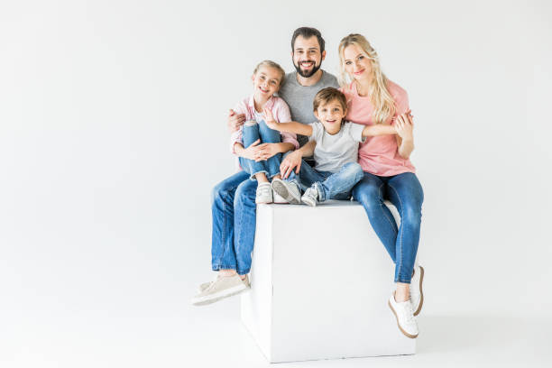 Studio portrait of a Latin American couple and their little son supporting each other in some difficult times