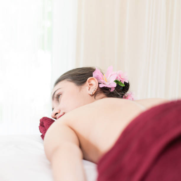 istock Woman half naked lying down on Spa bed for massage 910145308