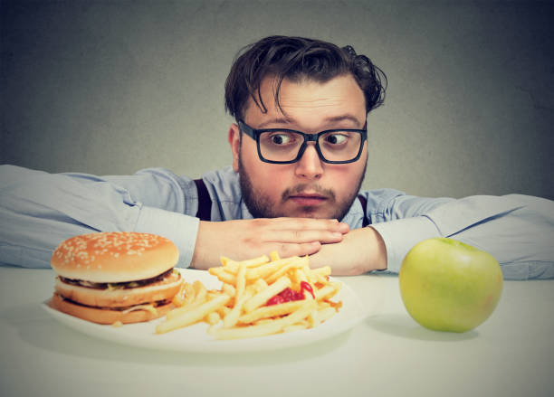 istock Obese man concerned with diet choice 910145338