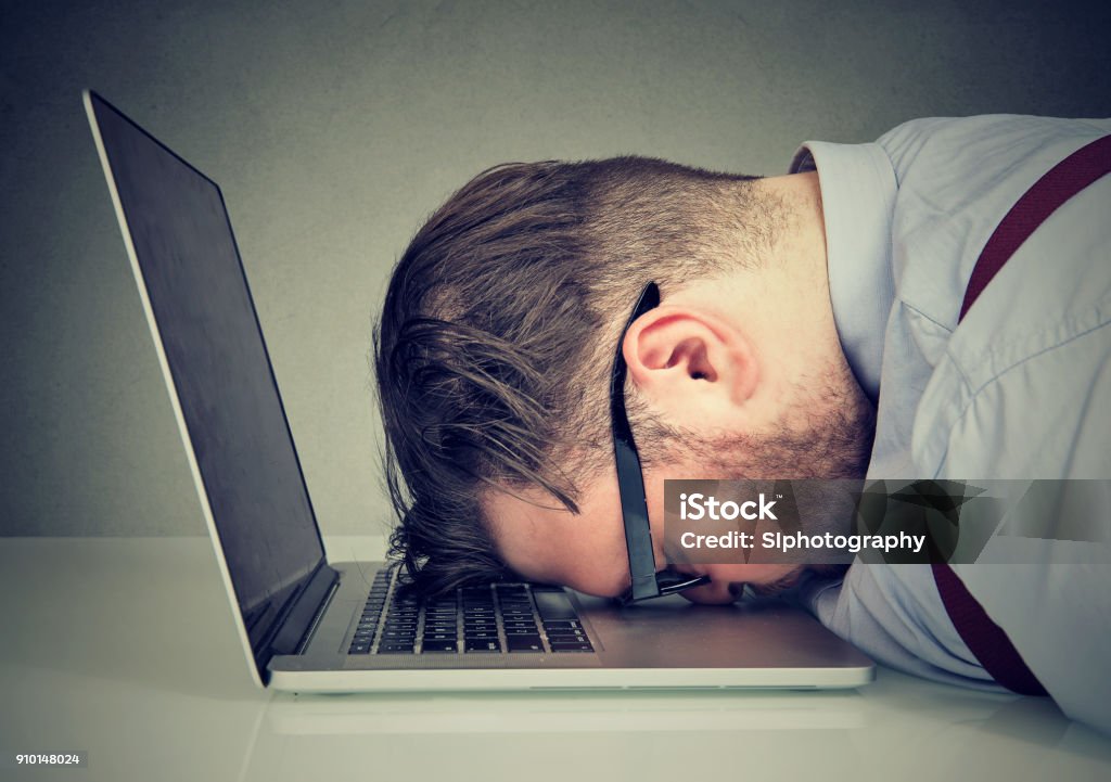 Uomo troppo troppo lavoro sdraiato sul laptop - Foto stock royalty-free di Frustrazione
