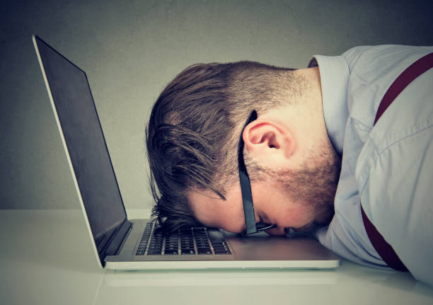 Overworked man lying on laptop Side view of chubby man looking broken while lying on top of laptop. business failure stock pictures, royalty-free photos & images