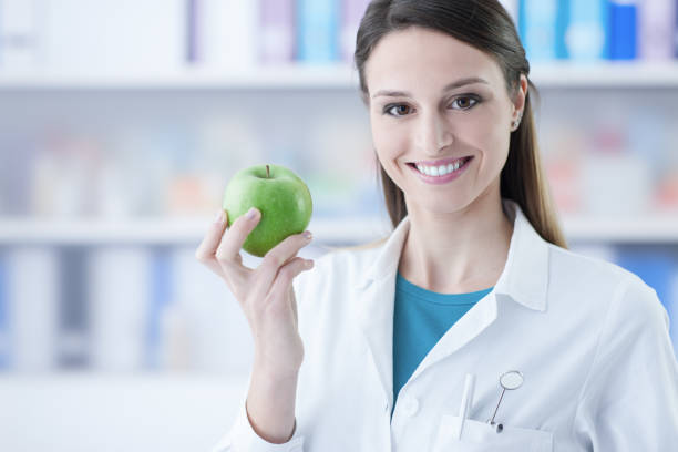 istock Dentist holding a green apple 910148528