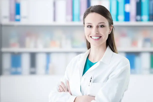 Confident smiling female doctor posing in the office, healthcare concept