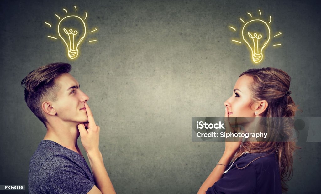 Content couple having great idea Young people man and woman posing together enlightened with idea looking positive. Inspiration Stock Photo