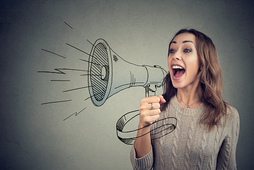 Content young woman screaming in loudspeaker making announcement.