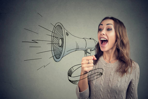 Cheerful woman sharing with news using loudspeaker Content young woman screaming in loudspeaker making announcement. reportage photos stock pictures, royalty-free photos & images
