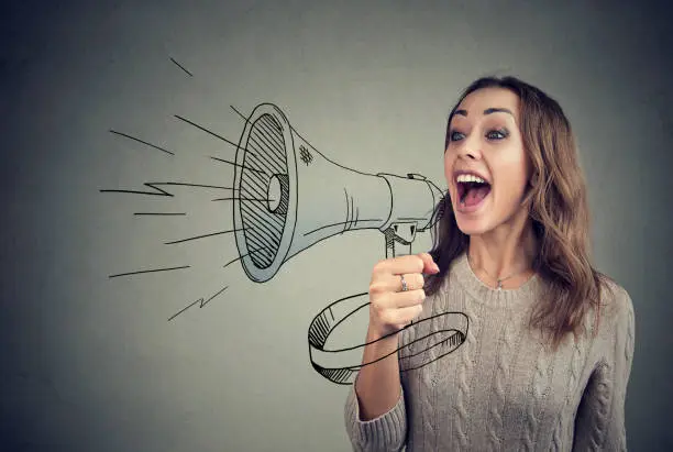 Photo of Cheerful woman sharing with news using loudspeaker