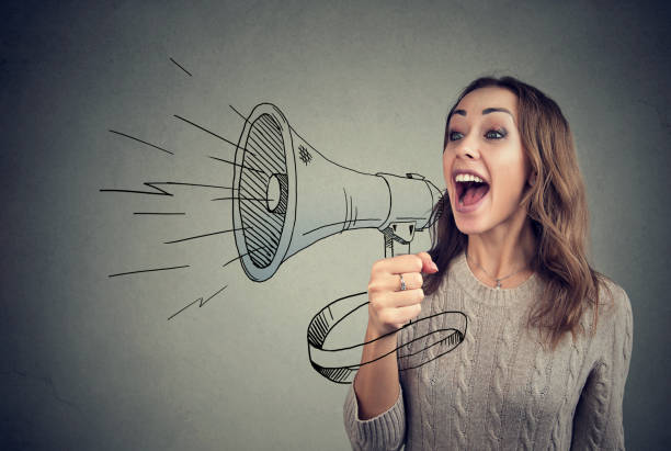 cheerful woman sharing with news using loudspeaker - loud voice imagens e fotografias de stock