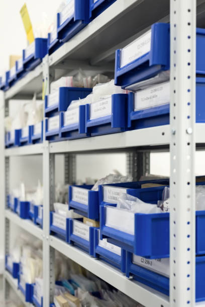 istock Industrial warehouse. White metal racks with blue plastic trays and cardboard boxes installed in them 910154856
