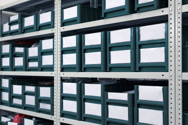 istock Industrial warehouse. White metal racks with blue plastic trays and cardboard boxes installed in them 910155056