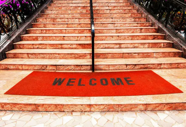 Photo of welcome plastic red carpet in front of the marble staircase at the hotel