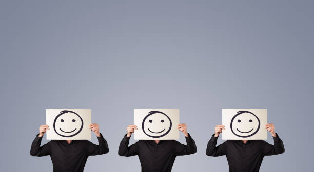 istock Men in suit gesturing with sketched smiley faces on cardboard 910155946
