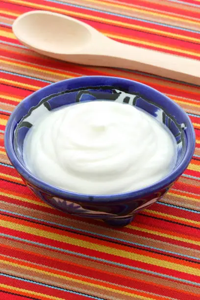 Delicious sour cream a traditional ingredient in France, Russia, Eastern European, German cooking and mexican cuisine. On terracotta or talavera artisan bowl
