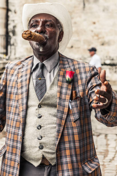 Cuban performer smoking a huge cigar at Plaza Vieja in Old Havana, Cuba. Havana, Cuba - June 3, 2013 : Cuban performer smoking a huge cigar at Plaza Vieja in Old Havana, Cuba. cuban man smoking big cigar stock pictures, royalty-free photos & images