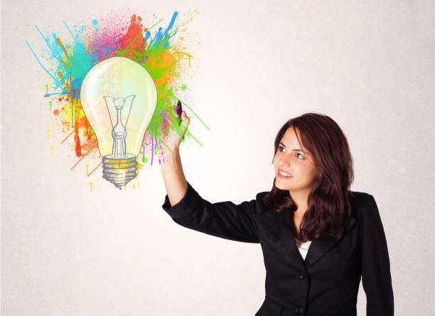 istock Young lady drawing a colorful light bulb with colorful splashes 910159006