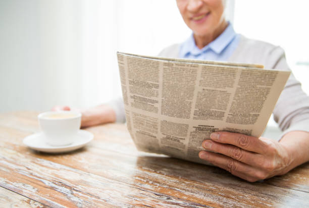 istock senior woman with coffee reading newspaper at home 910159708