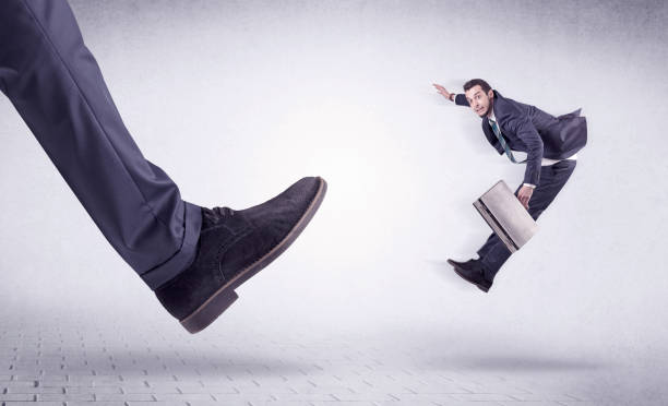 istock Young worker kicked out by big foot 910159786