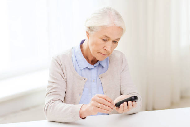 istock senior woman with glucometer checking blood sugar 910162056
