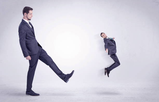 istock Big man kicking little himself out 910166118